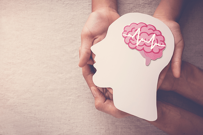 Adult and child hands holding an encephalography brain paper cutout