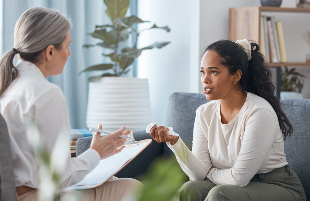 Shot of an attractive young woman sitting and talking to her psychologist during a consultation - Texas Hospital Association
