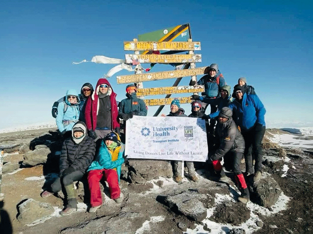 Dr. Kelley Hitchman and team summit Mt. Kilimanjaro with University Health sign