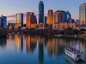 The Austin skyline at sunset, viewed from a boat on Lady Bird Lake.
