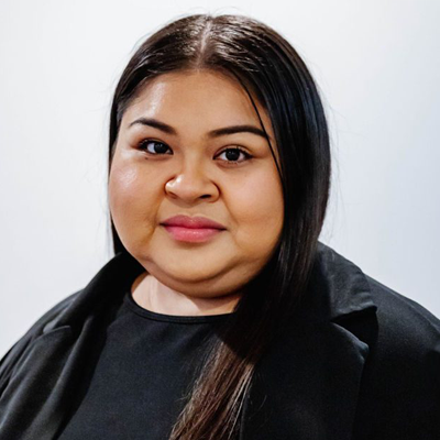 Evelin Manzanares - Texas Hospital Association Portrait of a woman with long dark hair wearing a black top and blazer against a light background, looking at the camera with a subtle smile.