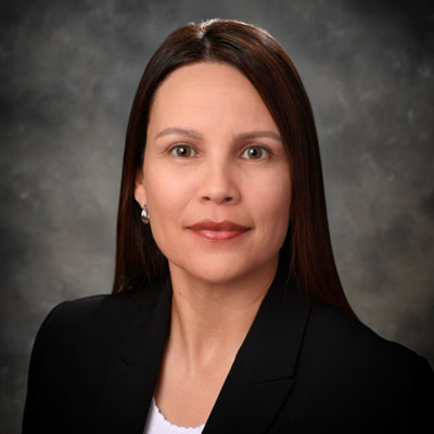 Rene Havel - Texas Hospital Association Professional headshot of a woman with dark brown hair in a black blazer, against a gray studio background.