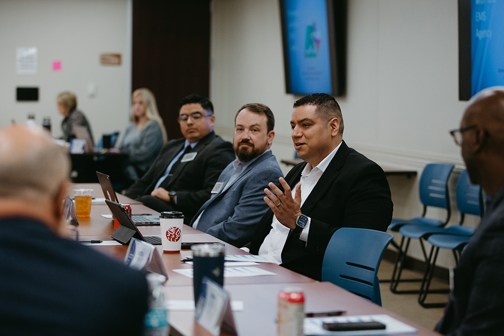 THA Fellows Class of 2026 participating in discussion - Texas Hospital Association Businesspeople seated around a conference table during a panel discussion, with laptops and drinks nearby.