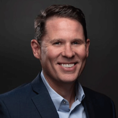 Richard Lear - Texas Hospital Association Smiling man in a navy blazer and light blue shirt against a dark studio backdrop.