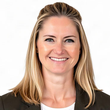 Smiling professional woman with shoulder-length blond hair wearing a dark blazer against a white background.