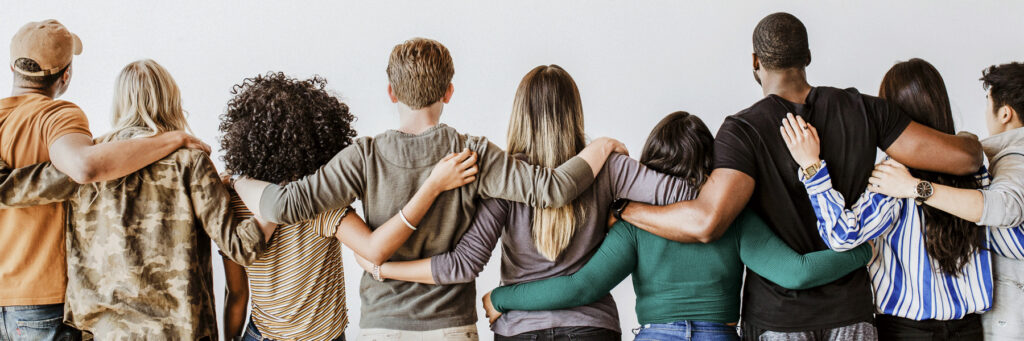 Group of people with arms around each other, facing away from the camera, showing friendship and unity.