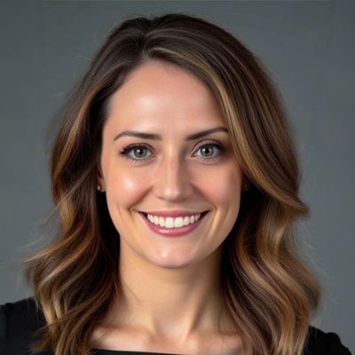 Cilia Stelly - Texas Hospital Association Head-and-shoulders portrait of a smiling woman with shoulder-length wavy brown hair against a gray background.